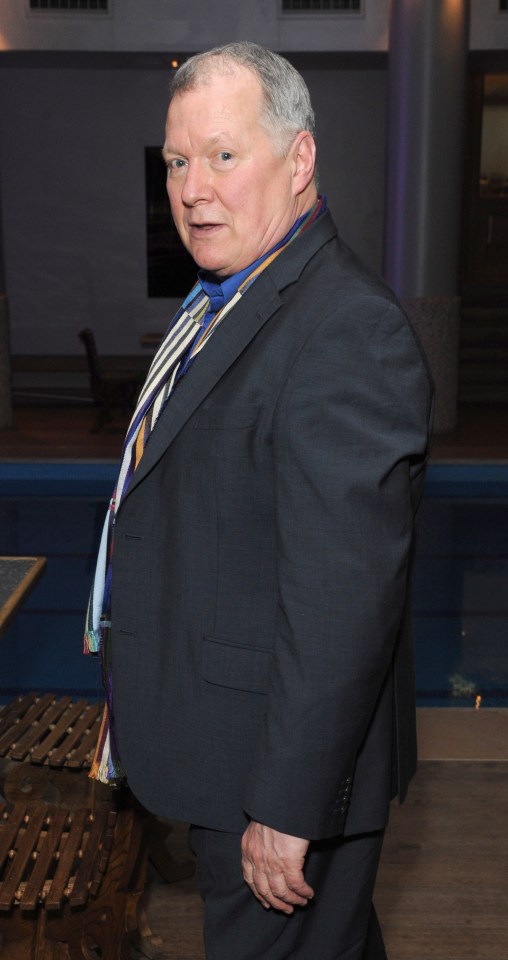 a man in a suit and tie stands in front of a pool