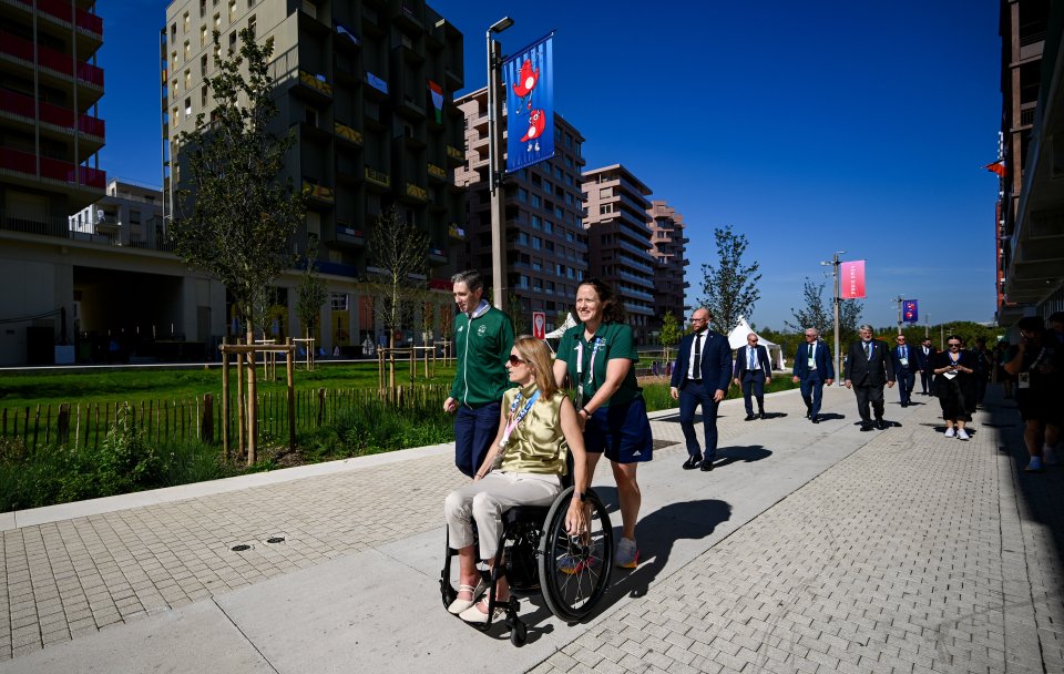 a woman in a wheelchair is being pushed by two people