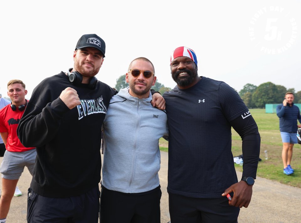 a man wearing a everlast sweatshirt poses with two other men