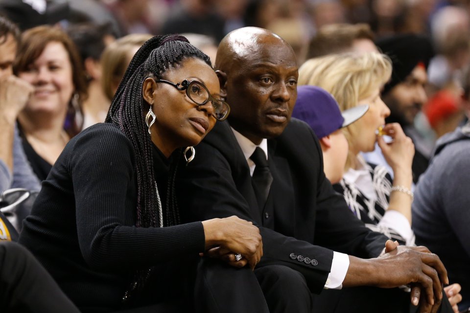 a man and a woman sit in a crowd watching a game