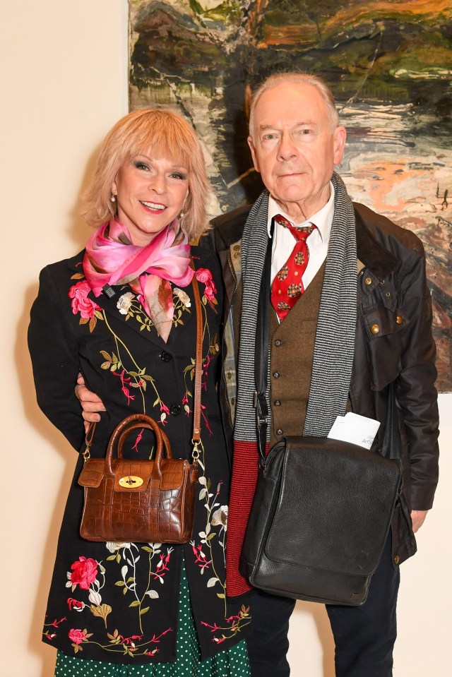 a man and a woman posing for a picture with a purse that says mulberry on it