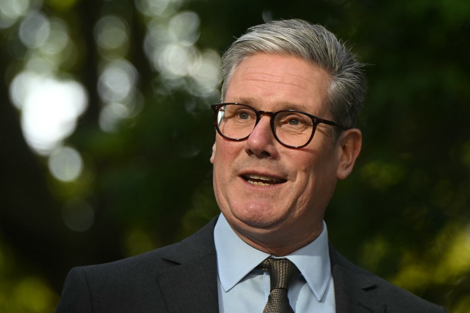 a man wearing glasses and a suit is smiling