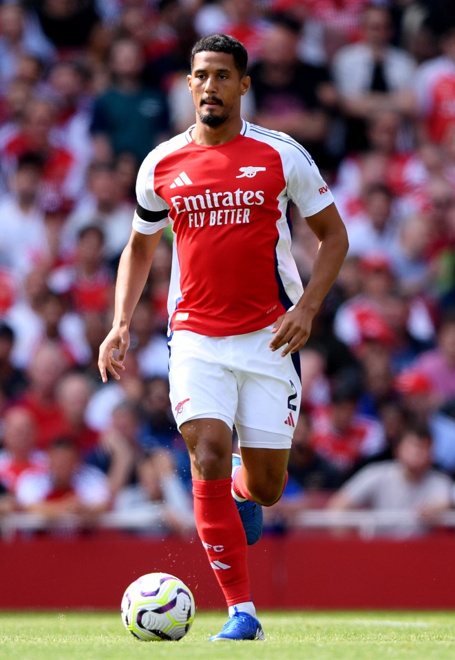 a soccer player wearing a red and white jersey that says emirates fly better