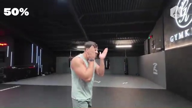 a man is standing in a gym with his hands in the air .