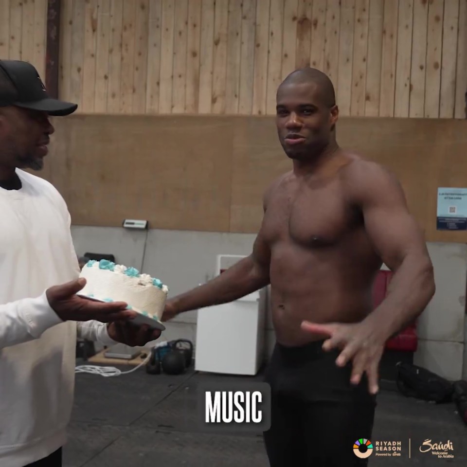 a man holding a cake in front of a sign that says music