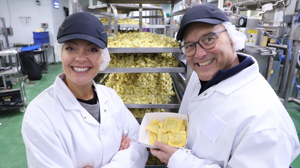 a man and a woman standing next to each other in a kitchen