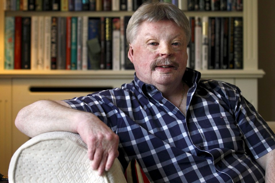 a man wearing a plaid shirt with the letter n on it