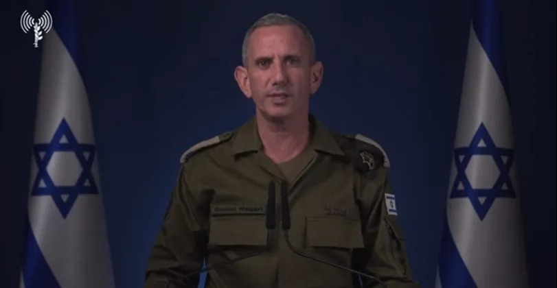 a man in a military uniform stands in front of two flags with a star on them