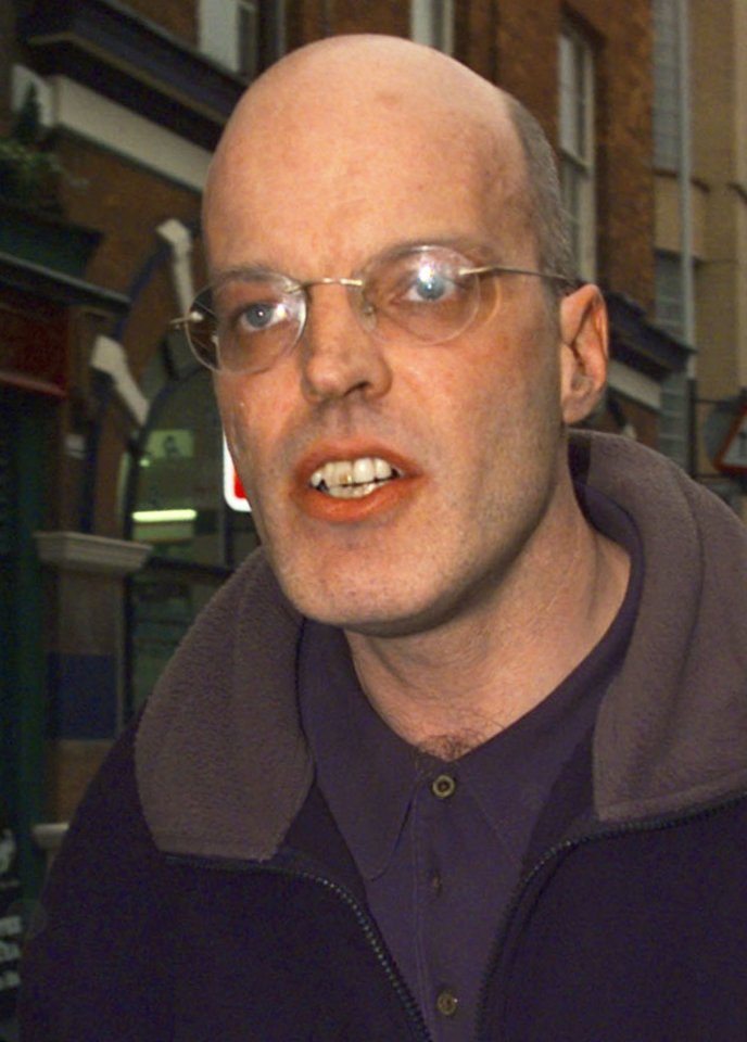 a bald man wearing glasses and a purple shirt