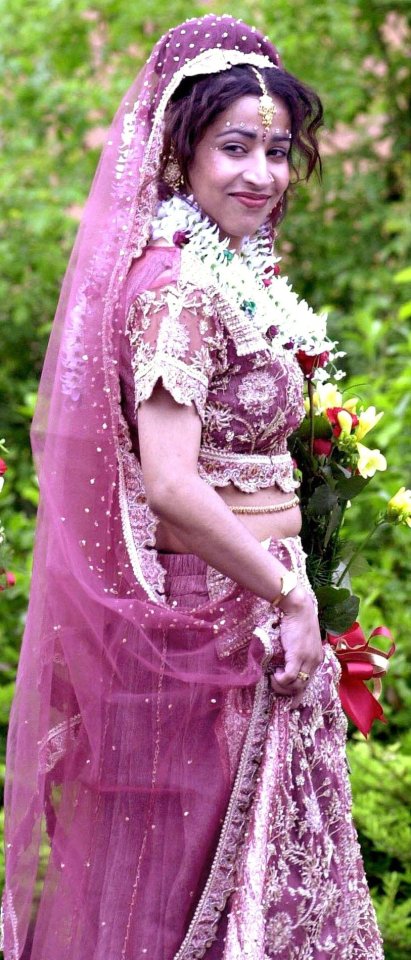 a woman in a pink dress is holding a bouquet of flowers