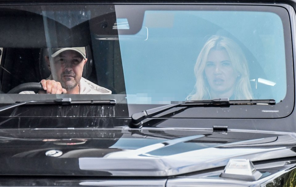 a man wearing a ny hat sits next to a woman