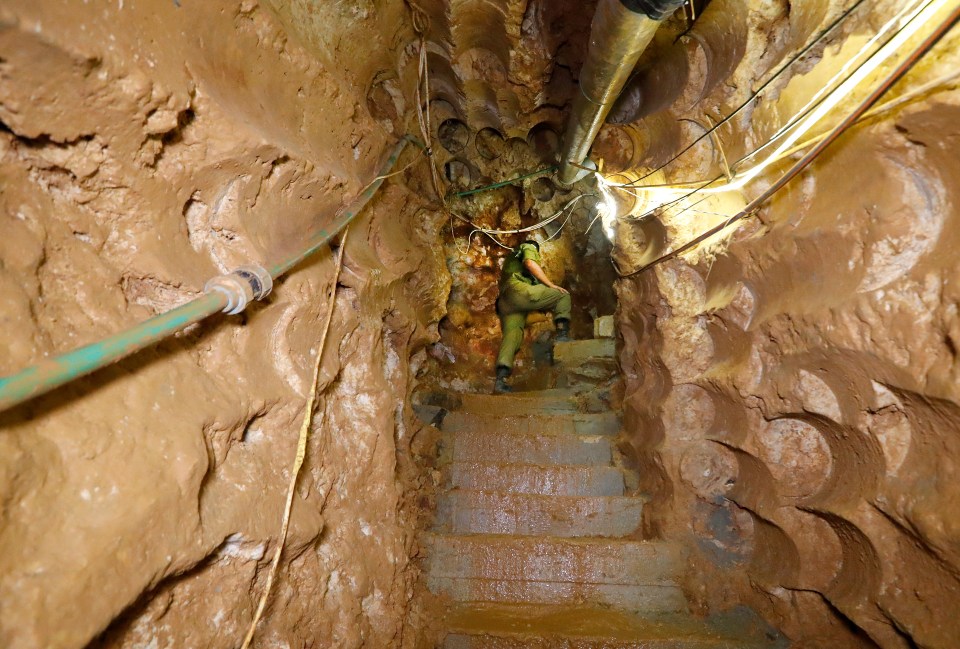 a person walking down a set of stairs in a cave