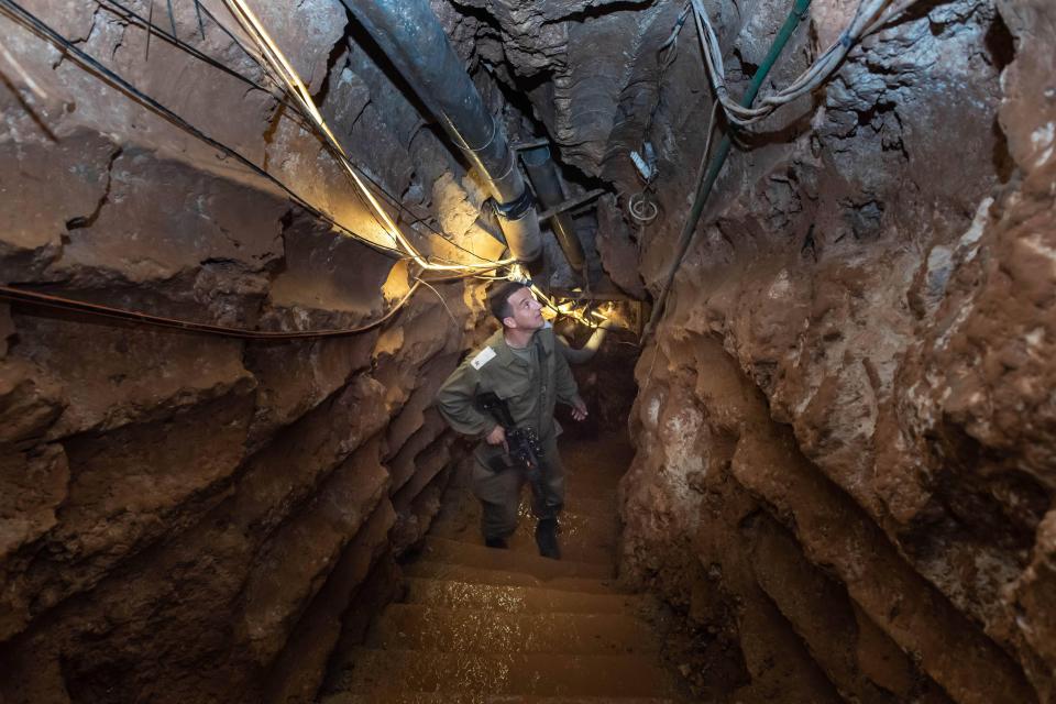 a man in a military uniform stands in a tunnel