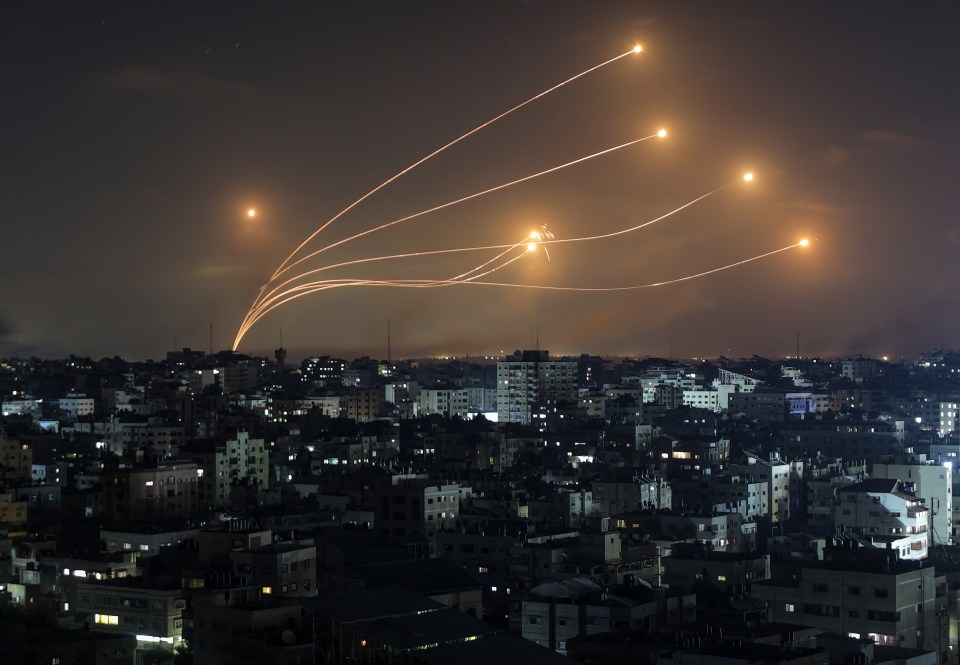 a bunch of rockets are flying over a city at night