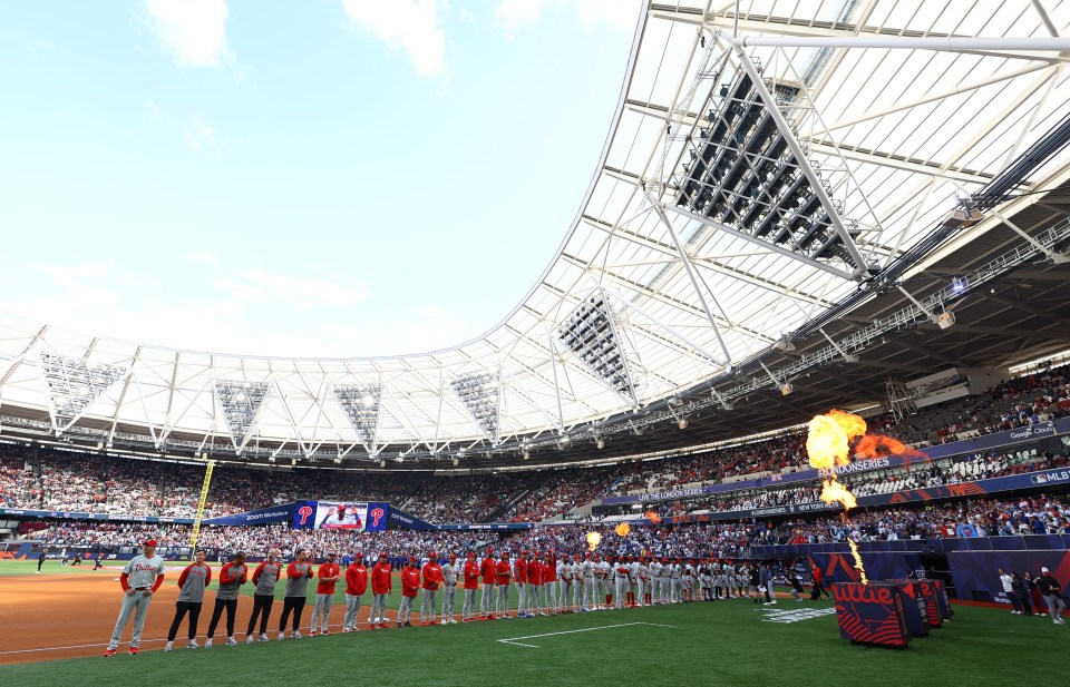 a group of players stand on a field in front of a stadium that says all star