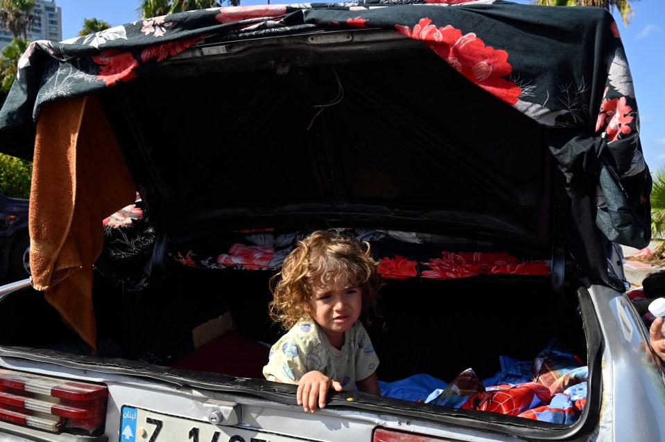 a little girl sits in the back of a car with a license plate that says 7