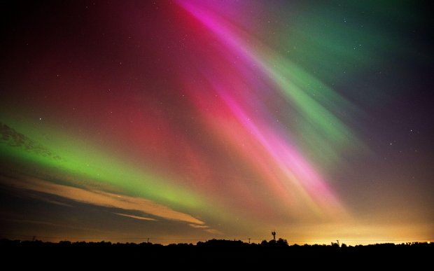 the aurora borealis shines brightly in the night sky