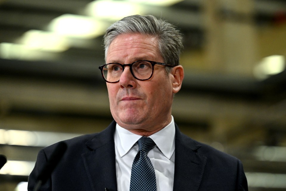 a man wearing glasses and a suit looks to the side