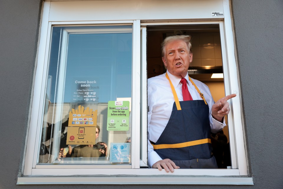 a man in an apron stands in front of a window that says come back soon
