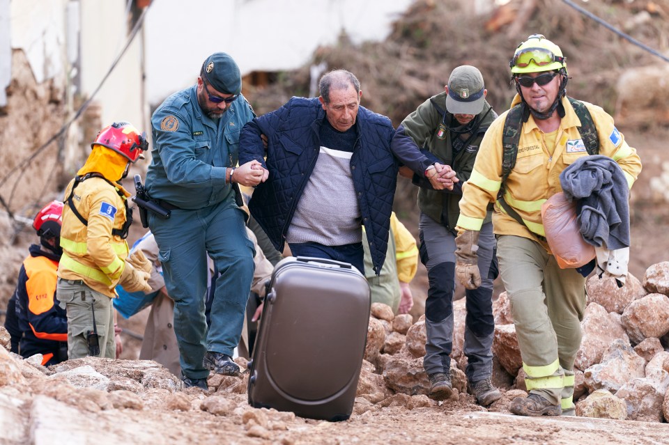 Emergency workers rescue a man the flooding