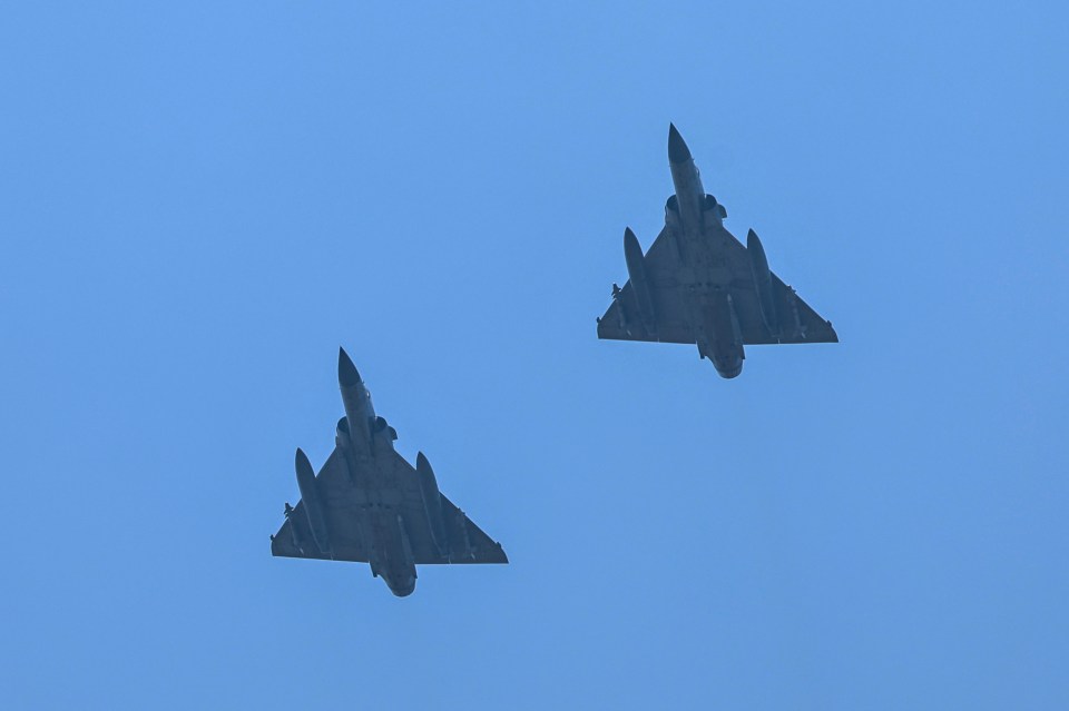 two fighter jets are flying side by side in the sky