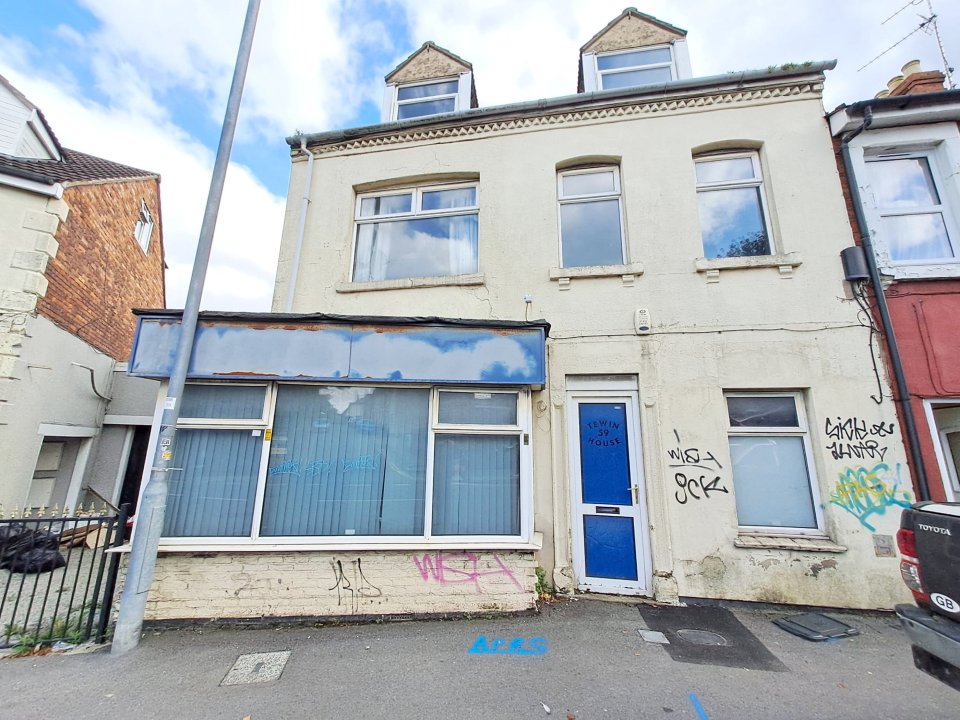 a white building with a blue door and graffiti on it