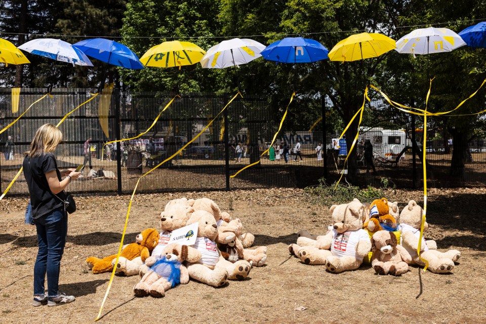 a woman takes a picture of teddy bears wearing shirts that say autism