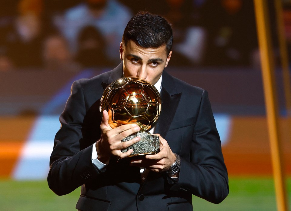 a man in a suit is kissing a soccer ball
