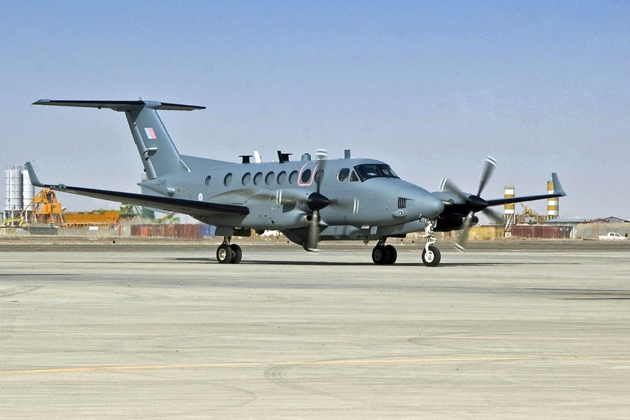 a gray airplane with a british flag on the tail sits on a runway