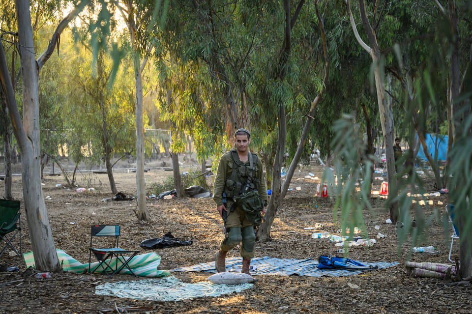 a man in a military uniform stands in the middle of a forest