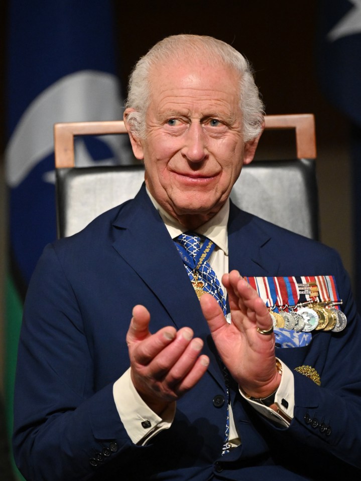 a man in a suit and tie is clapping his hands