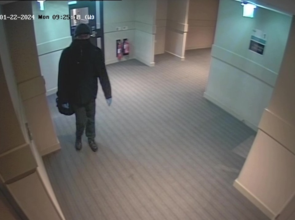 a man walking down a hallway with the date of 01-22-2021