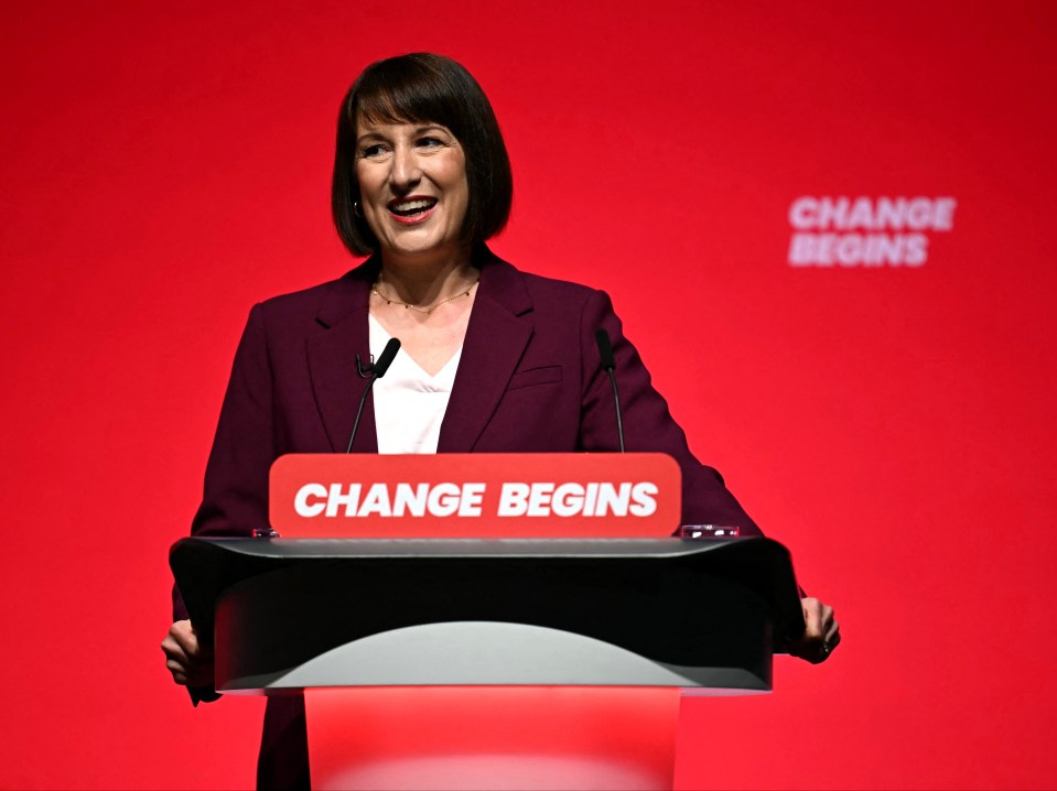 a woman stands behind a podium that says change begins