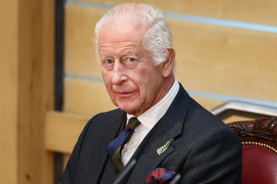 a man in a suit and tie is sitting in front of a microphone
