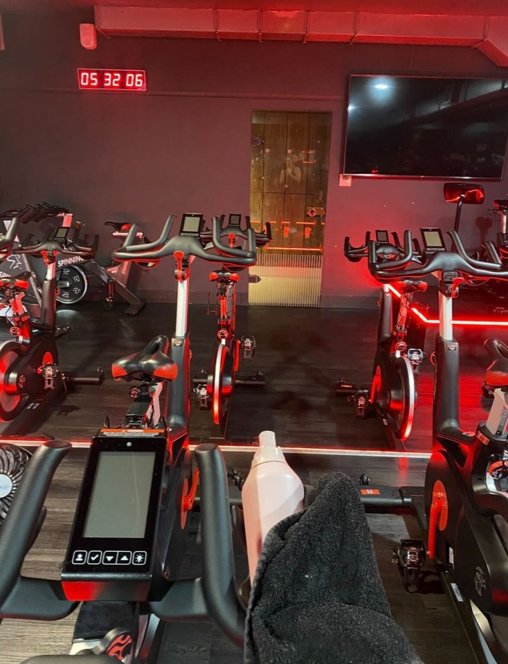 a row of exercise bikes in a gym with a digital clock that reads 05 32 06