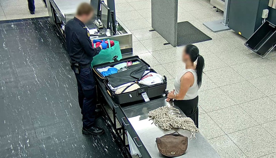 a woman standing next to a suitcase with a tag that says ' a ' on it