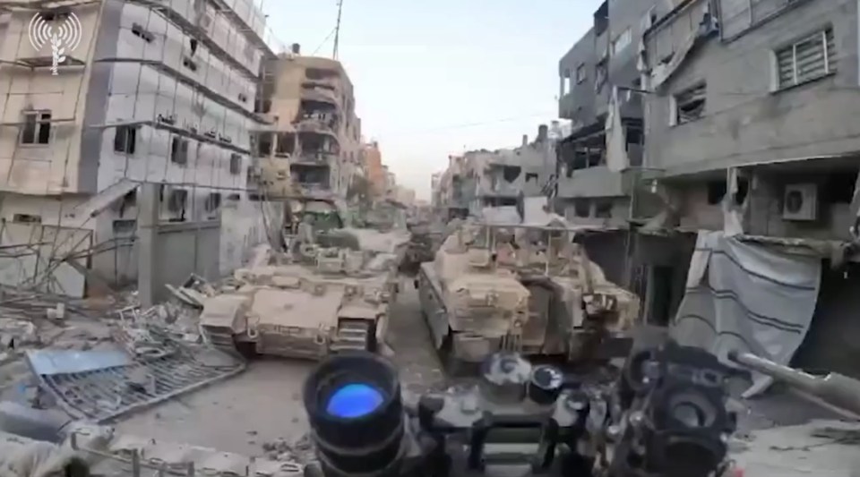 a soldier is looking through a binoculars at a row of tanks