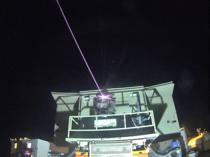 a purple light is being projected on a building with the letter a on it