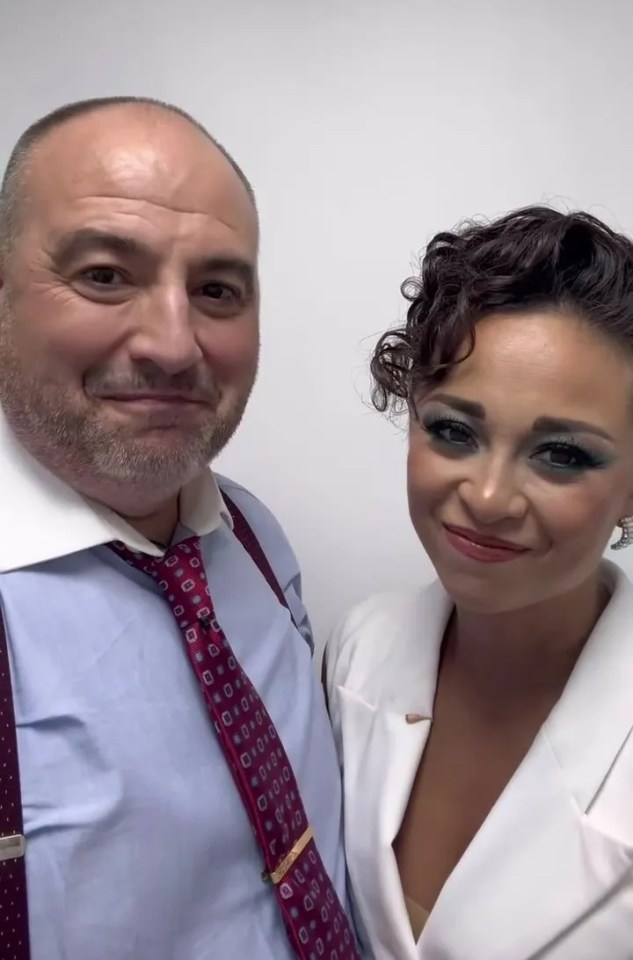 a man and a woman are posing for a picture and the man is wearing a red tie