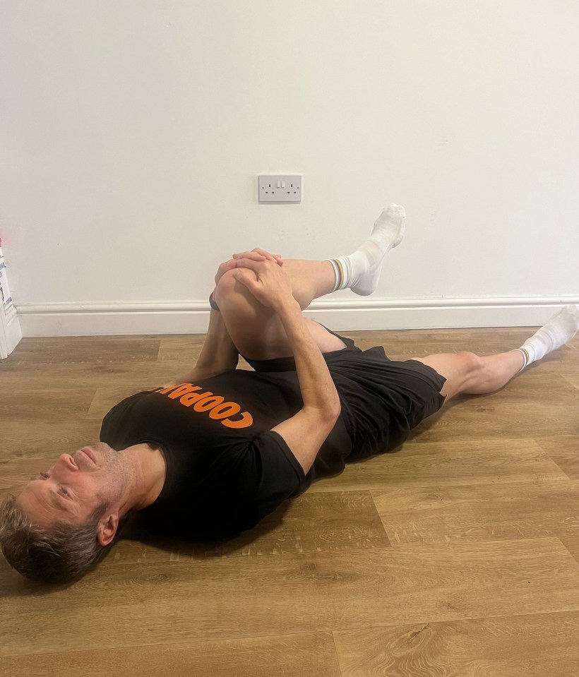 a man is laying on the floor with his legs crossed and his shirt says cooper