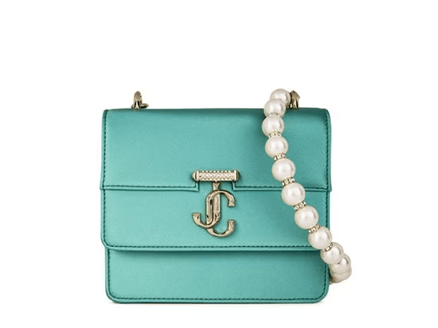 a turquoise purse with pearls and a jc logo