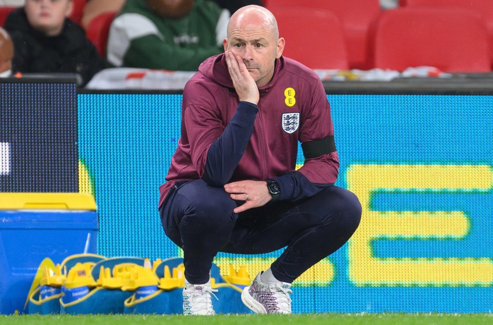 a man squatting on a soccer field in front of a sign that says ee