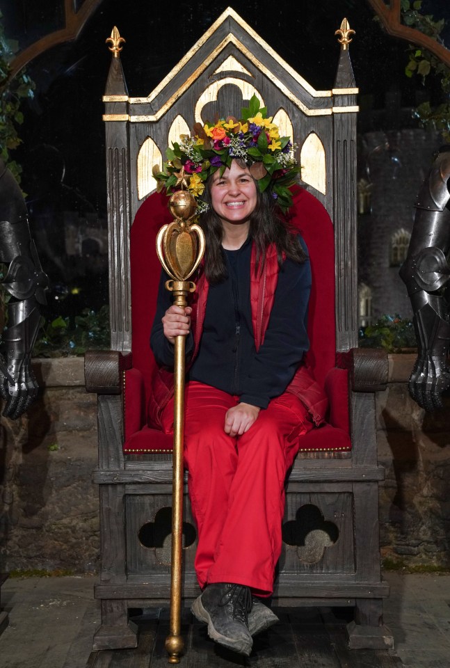 a woman is sitting on a throne with a crown of flowers on her head