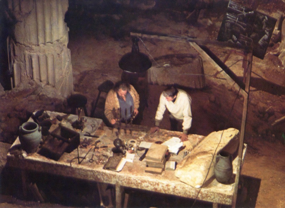 two men are working on a table in a dark room