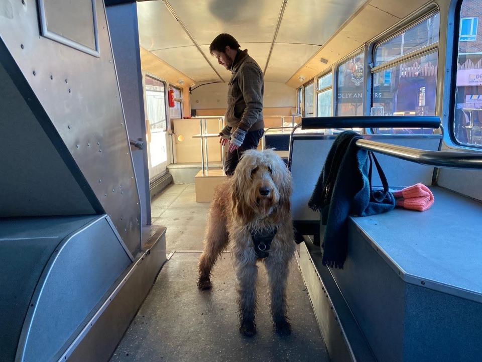 a man and a dog on a bus with a sign that says olly 's