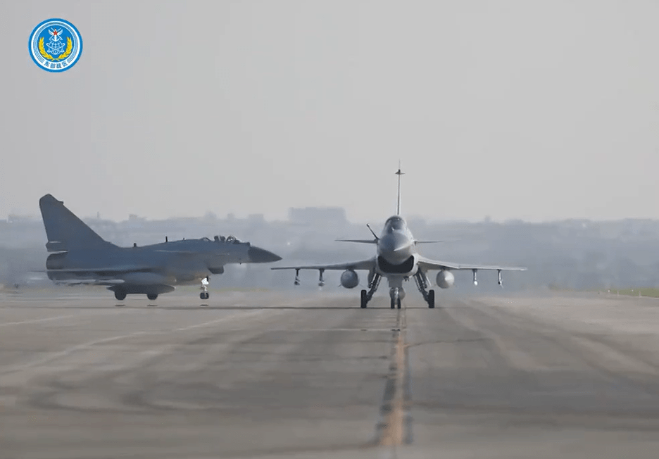two fighter jets on a runway with a blue logo on the bottom
