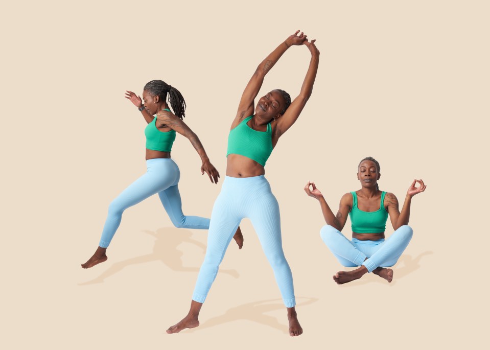 a woman in a green top and blue leggings is jumping in the air