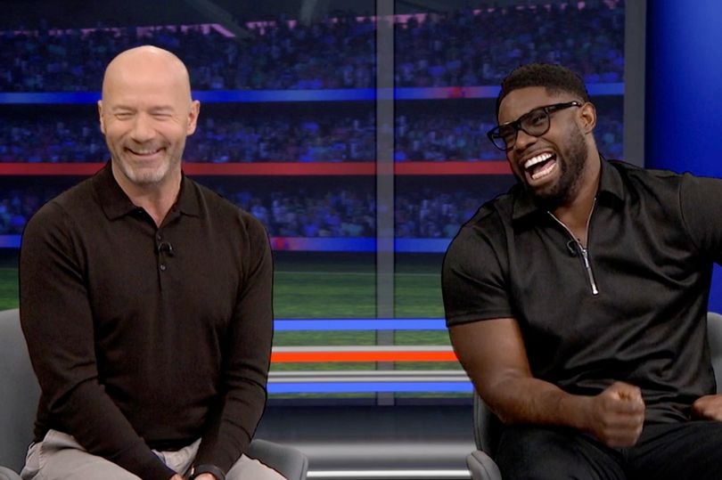 a bald man and a black man are sitting next to each other and laughing