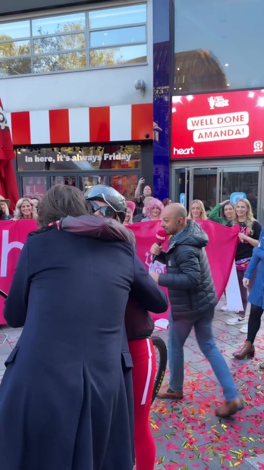people hugging in front of a sign that says well done amanda