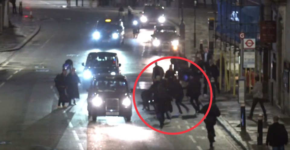 a group of people are walking down a street with a red circle around them